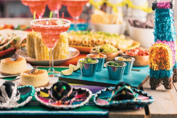 Bright Cinco de Mayo party table with colorful margarita, fresh guacamole, tortilla chips, and vibrant festive decor